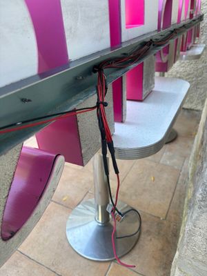 une rangée de bancs roses et blancs sur un trottoir