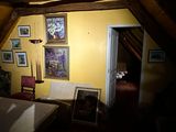 a room with a bed, a chair and pictures on the wall
