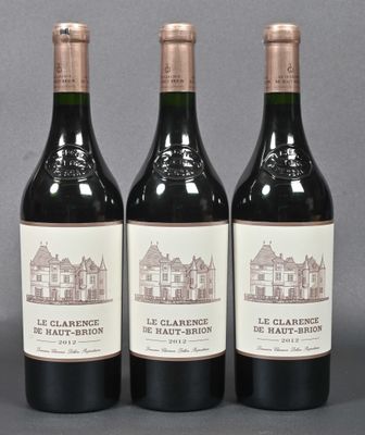 three bottles of red wine sitting on top of a table