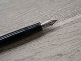 a fountain pen sitting on top of a wooden table
