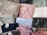 de nombreux sacs de vêtements empilés les uns sur les autres sur une table