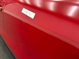 a red car that has a sticker on the side of it