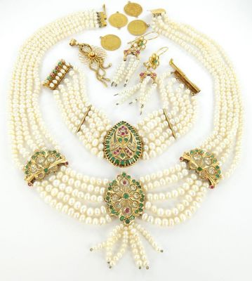 une collection de bijoux en perles et en or, comprenant un collier, des boucles d'oreilles et une broche