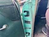 a green car door handle with a hole in it