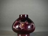 a purple vase with flowers on it sitting on a table