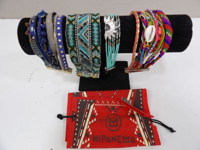 many different bracelets on display on a black stand