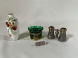 un petit vase, une bouteille et une paire de jumelles posés sur une table