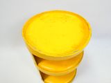 une table jaune sur laquelle est posée une pile d'assiettes jaunes