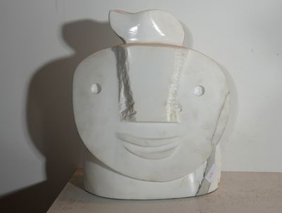 un vase blanc orné d'un visage, posé sur une table