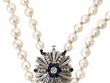 un gros plan sur un collier orné de perles et d'une fleur