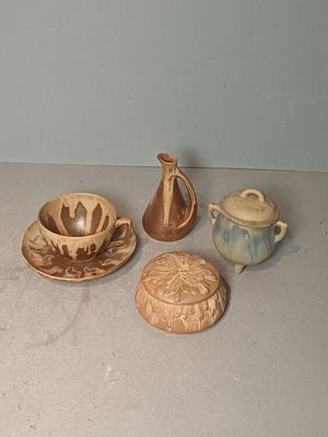 four different pieces of pottery sitting on a table