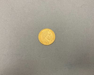 une pièce d'or sur une surface grise