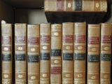 many old books on a shelf in a book case