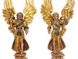 pair of gold angel figurines with wings on pedestal