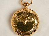 an image of a gold pocket watch on a white cloth