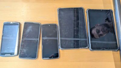 Plusieurs téléphones portables sont alignés sur une table