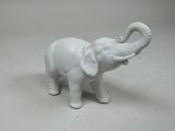 a white elephant figurine that is standing on a table