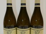 trois bouteilles de vin posées sur une table l'une à côté de l'autre