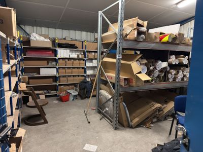une pièce remplie de cartons, avec d'autres cartons sur les étagères