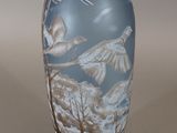 a vase with a picture of birds flying in the sky