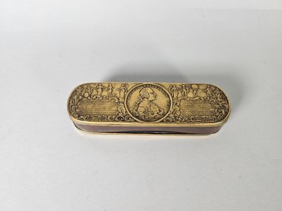 un étui à cigarettes ancien en laiton, orné d'une image représentant un homme et une femme