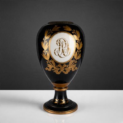 urne noire et dorée, ornée d'une initiale sur le devant