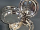 trois assiettes plaquées argent posées sur une table avec un fond noir
