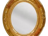 un miroir rond avec un cadre doré sur fond blanc