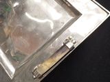 a silver tray with a picture on it on a black surface