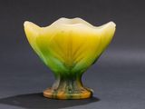a yellow and green glass vase sitting on top of a table