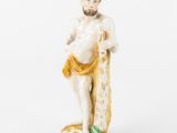 une vieille figurine représentant un homme tenant une planche de surf sur un fond blanc