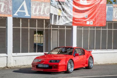 une voiture rouge garée devant un bâtiment