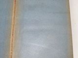 an open book on a white table with a red cover