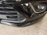 a close up of a black car that is parked in a garage