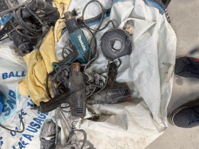 un tas d'outils par terre, avec une personne debout à côté