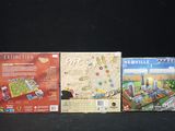 four board games are lined up on a black surface
