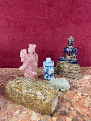 a small statue of a buddha sitting on a rock next to other items