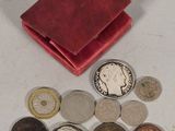 a small red wallet with coins on a white table