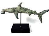 sculpture of a shark on a black stand on a white background