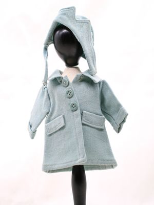 un mannequin vêtu d'un manteau bleu et d'un chapeau