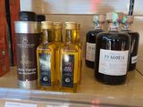 bottles of olive oil and other oils on a shelf in a store