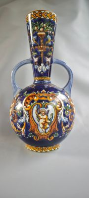 un vase bleu et jaune posé sur une surface blanche