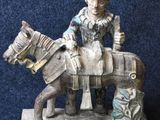 a figurine of a man riding a horse on a blue background