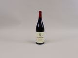 une bouteille de vin rouge posée sur une table blanche