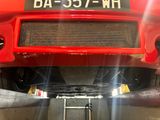 a close up of a red car with a number plate on it