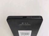 the back of a black cell phone sitting on top of a white table