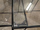 a glass table with a metal frame on top of it