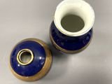 pair of blue and gold vases sitting on top of a table