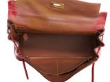 the inside of a brown leather purse with a red handle