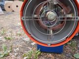 an orange and blue heater sitting on the ground next to a white truck